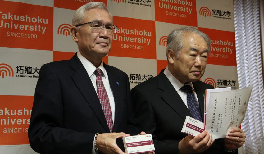 抗原検査キットなどを手にする廣上理事長（左）と篠塚学長（10月29日、拓殖大北海道短大）