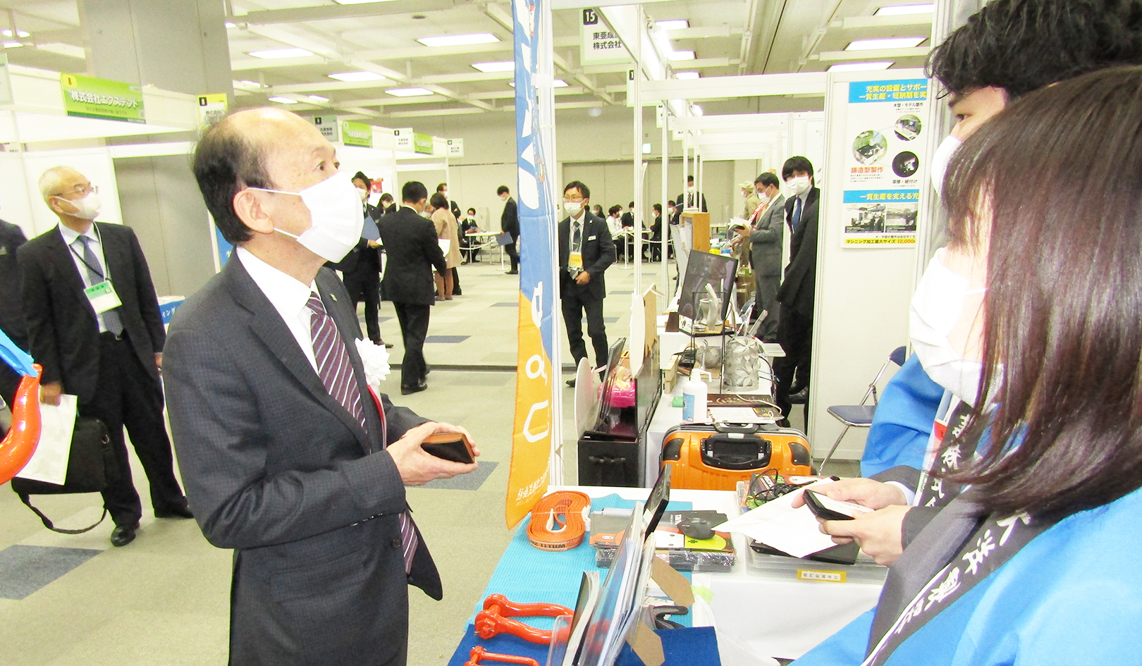 大洋製器工業のブースで説明を聞く須戸・北おおさか信金理事長（左、12月8日）