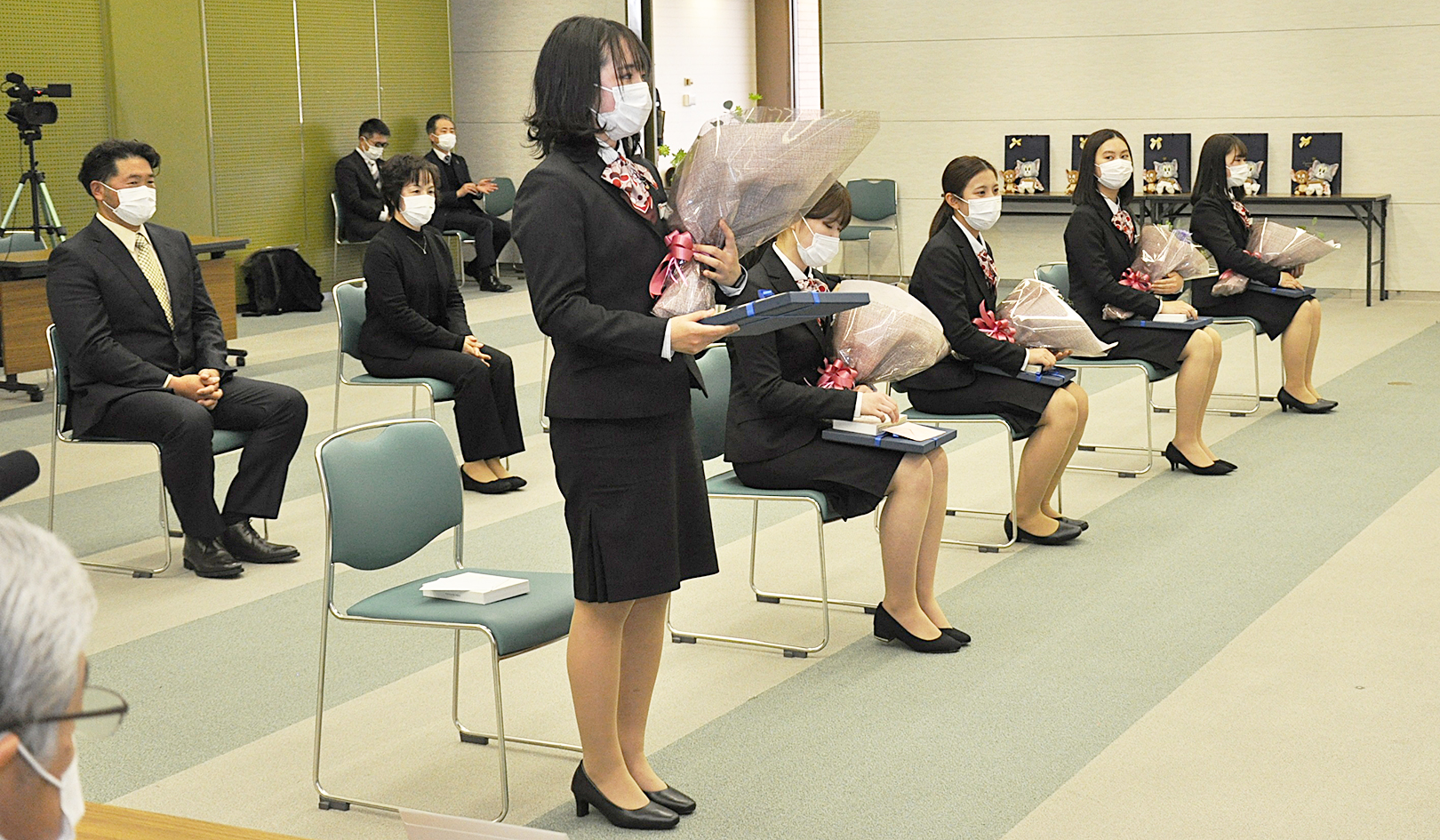 記念品と花束を受け取った新成人の5人（1月24日、本店大会議室）