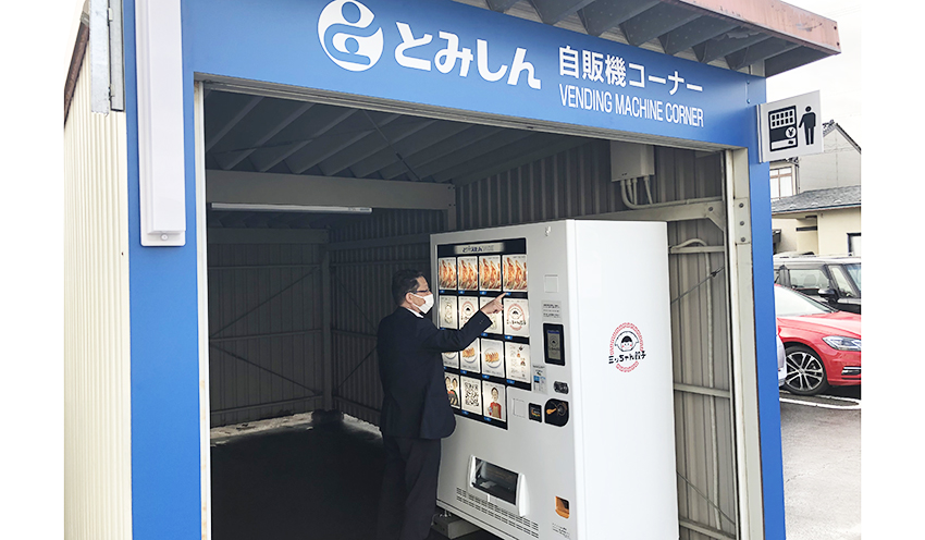 冷凍餃子自販機を利用する近隣のサラリーマン（12月２日、富山信金大泉支店）