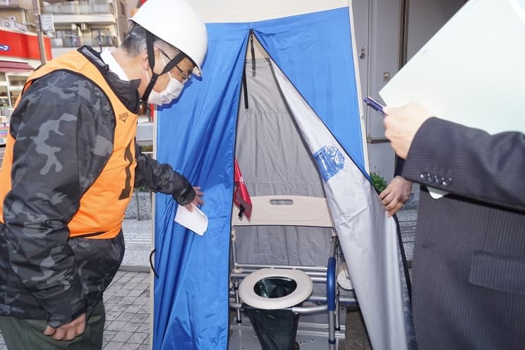 マンホールトイレを見学する訓練参加の住民（2月20日、足立成和信金本店本部で）