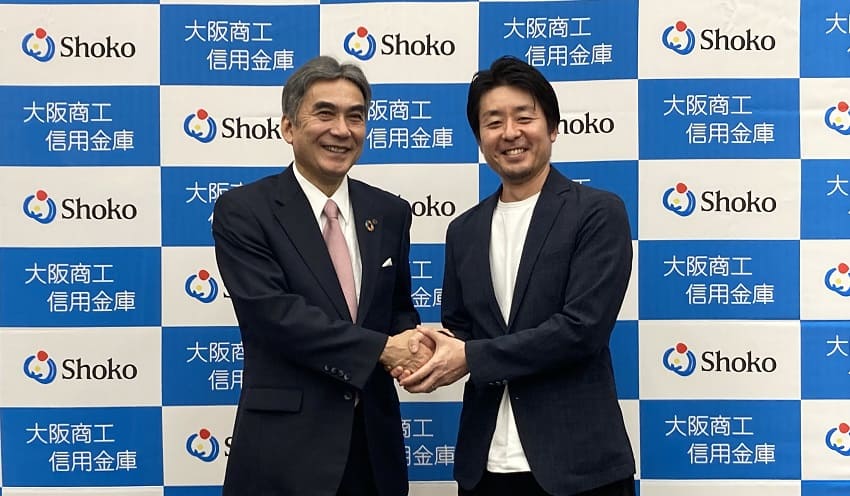 握手する多賀理事長(左)と近藤代表取締役CEO(3月28日、大阪商工信金)