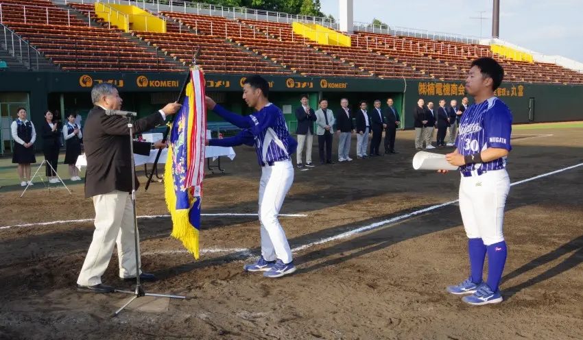 優勝した新潟信金チームには、西潟会長（左）から賞状と優勝旗が手渡された（5月20日、三条パール金属スタジアム）