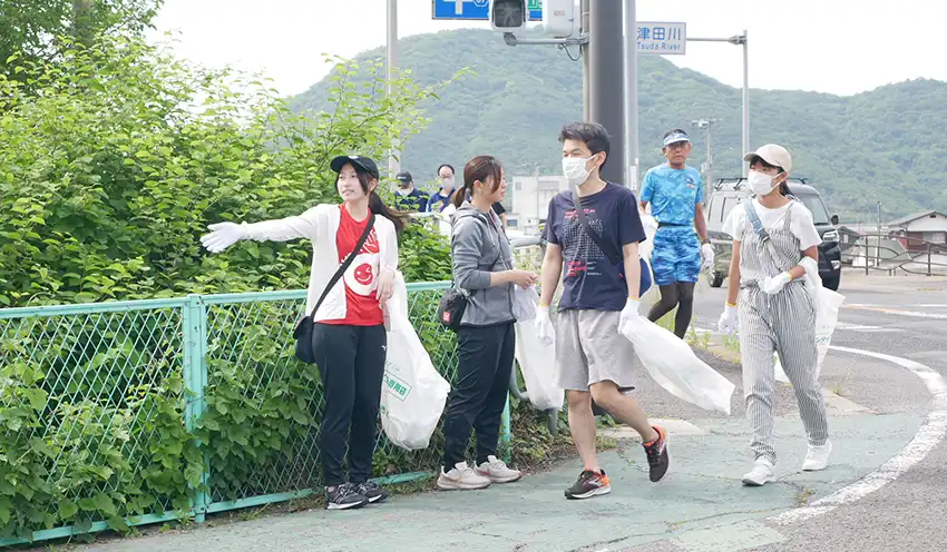 ごみ袋を片手に約１㌔㍍のコースを走り抜ける参加者（５月27日、さぬき市内）