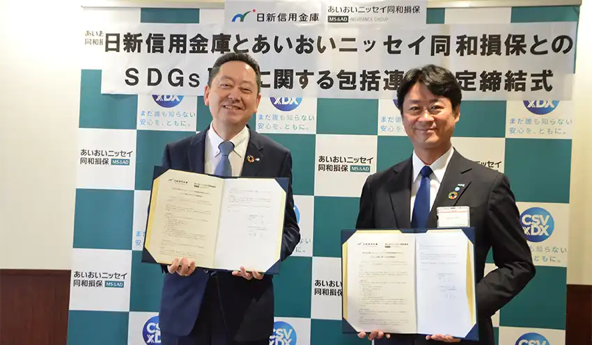 協定書を手にする日新信金の山本理事長(左)とあいおいニッセイ同和損保神戸支店の中澤支店長(6月13日、日新信金本店)