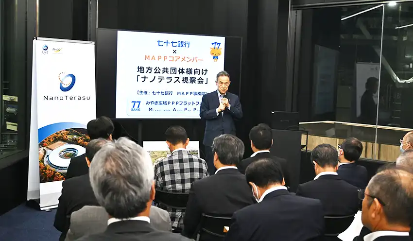 挨拶をする七十七銀の小林頭取（７月27日、ナノテラス）