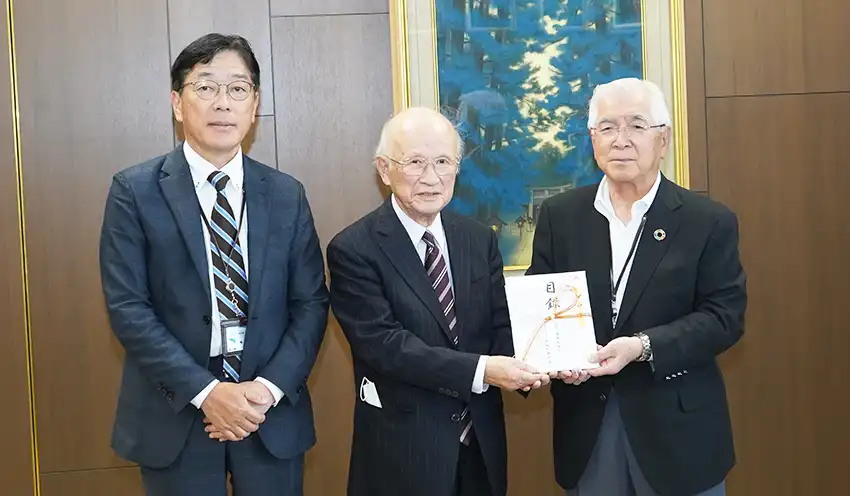 浜松いのちの電話の福永博文理事長（中央）に御室理事長（右）から目録が贈られた（5月21日、浜松いわた信金本部）
