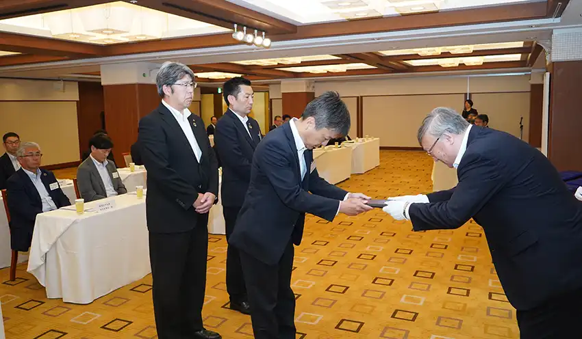 吉林会長（右）から感謝状を受け取る清水銀行東静岡支店の畔柳直之支店長（6月11日、中島屋グランドホテル）