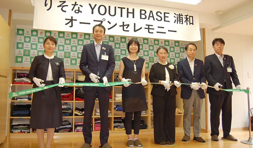 NPO法人関係者らとテープカットする福岡社長(左から2人目)と内田康将取締役兼専務執行役員(同6人目、8月27日、りそなYOUTH BASE 浦和)