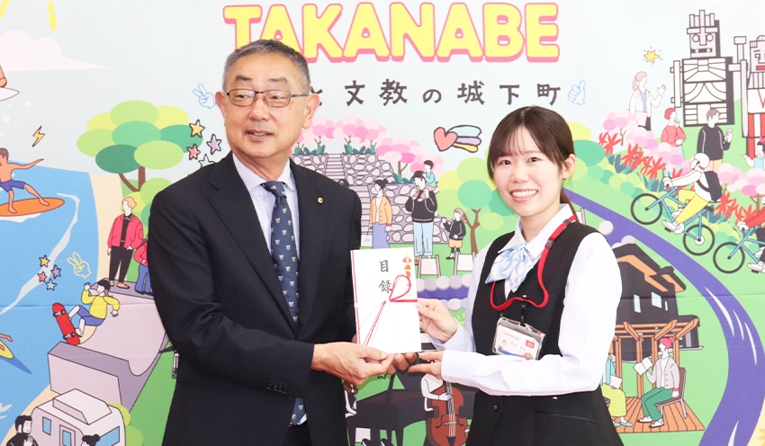 黒木町長（左）に目録を渡す本店営業部の西府真彩さん（右、11月8日、高鍋町役場）