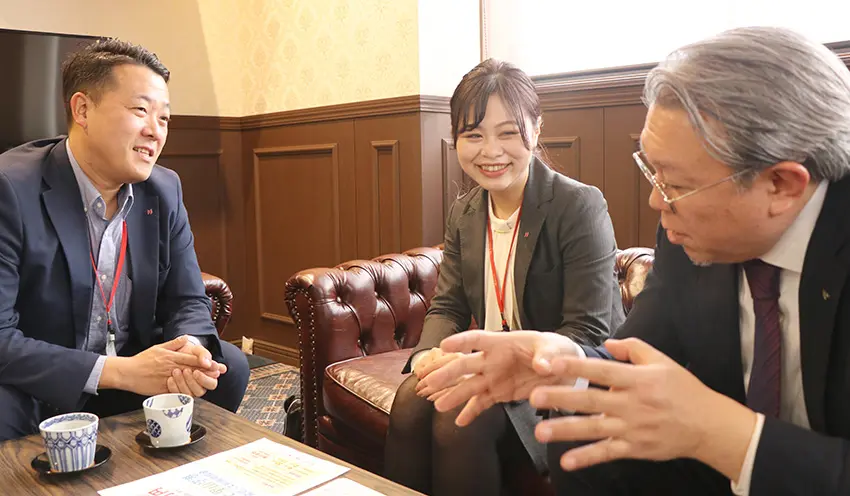 取引先の新日本ツーリスト・堅田芳弘社長（右）と情報交換する小田さん（中央、2月28日、石川県野々市市）