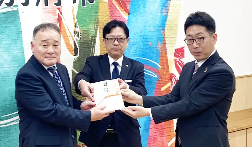 寄付金の贈呈式に参加した（左から）別府市の樋田英彦参事、ボルテックスの松岡明執行役員金融法人本部長、大分銀の吉武慎也福岡支店長兼博多支店長（2025年4月22日、別府市営温泉施設「不老泉」、ボルテックス提供）