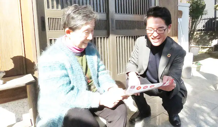 〝見守り隊〟活動で顧客宅を訪問する小田支店長(右、2月18日、福岡市)