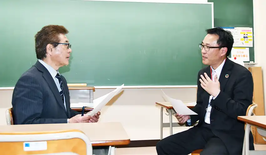担当教諭（左）と打ち合せする小山幸宏副支店長（４月１５日、幸手桜高校）