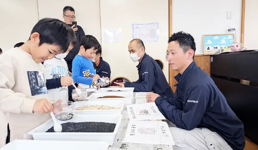 子供たちに有機肥料の作り方を教える水谷社長（右、4月18日、こども園みらい）