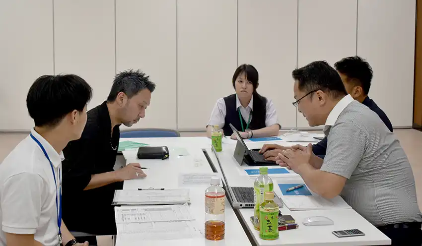 よろず支援拠点の専門家2人（右端と右から2人目）と相談する経営者（左から2人目、7月17日、館山信金本店）