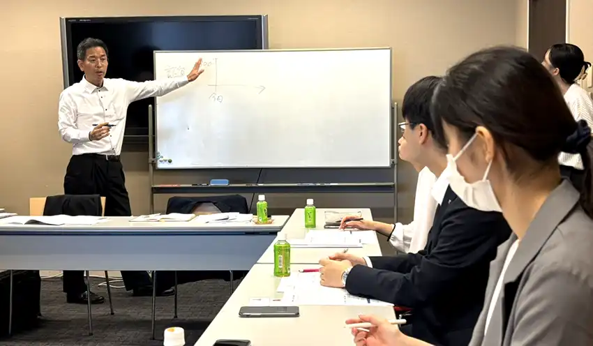 グラフを使い、証書貸し付けの仕組みを教える塚田氏（7月17日、富山市内）