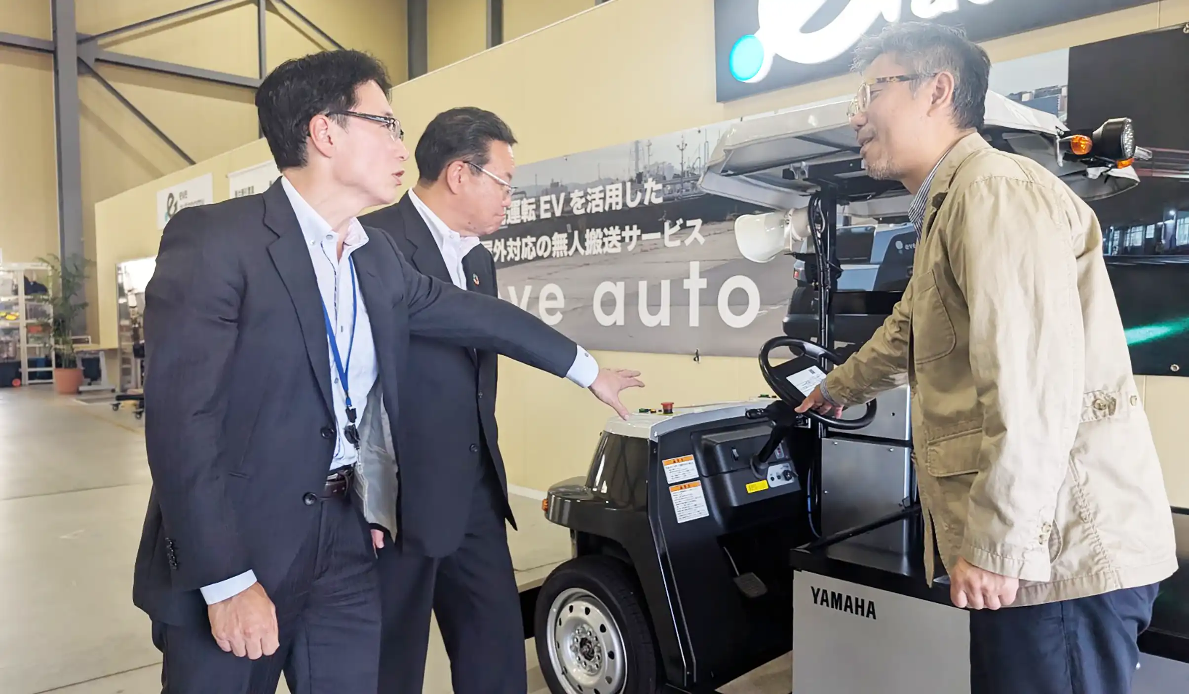 星野CEO（右）から無人運転の仕組みを聞く吉村重幸・静岡銀執行役員浜松営業部長（中央）、堀川有一・日本公庫浜松支店長（7月23日、イヴ・オートノミー本社）