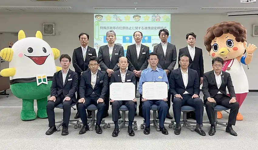 締結式に出席した須戸理事長(左から3人目)と6人の支店長、警察関係者(7月29日、北おおさか信金新北野別館)