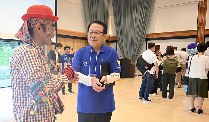プレゼンター(左)と交流する菅原理事長(7月12日、仙台市)