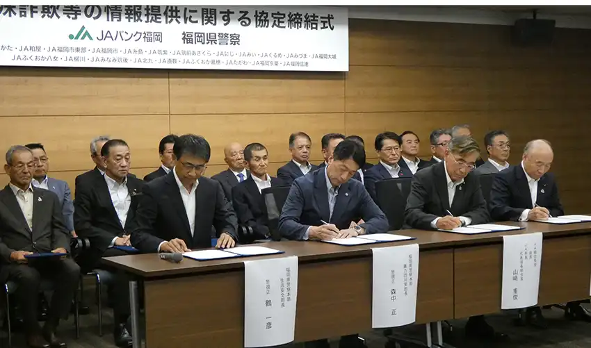 締結書に署名する白水会長（右、7月18日、JA福岡県会館）