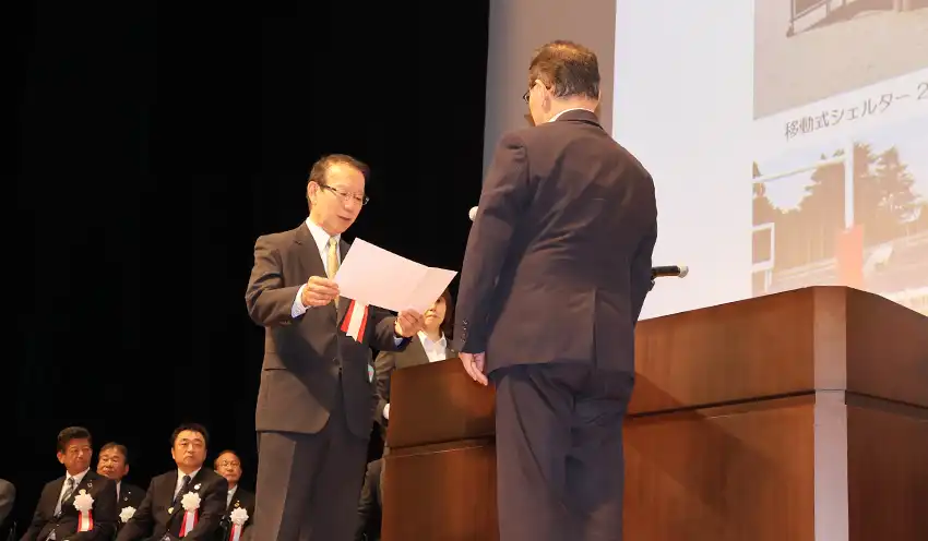 寄贈目録を手渡す吉野会長(7月24日、枚方市総合文化芸術センター)