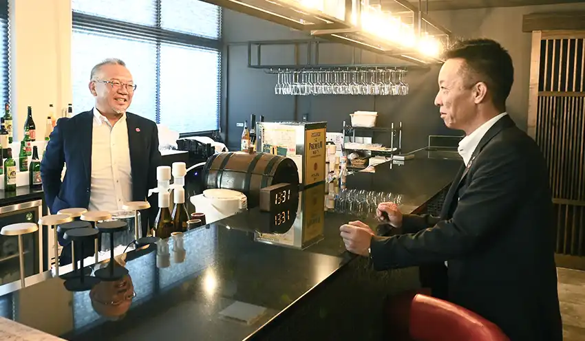 萬波に新設したバーカウンターで打ち合わせをする坂口社長（左）と賀見支店長（７月７日）