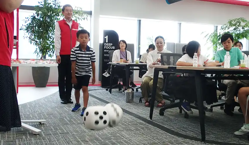 サイコロを振る小学生（7月24日、東京・日本橋）