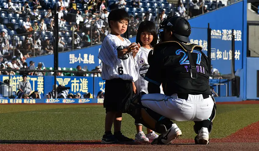 スターティングキッズでロッテの田村龍弘捕手からサインボールをもらう子供たち（7月21日、ZOZOマリンスタジアム）