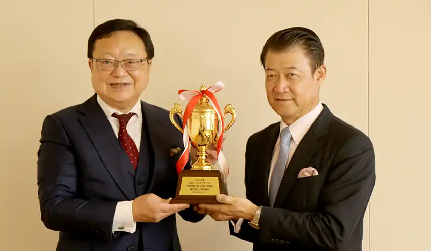 日本М＆Aセンターの三宅卓社長（左）から記念トロフィーを受け取る中澤頭取（8月5日、本店）