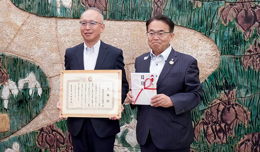感謝状を手にする藤原頭取（左）と目録を持つ大村知事（8月18日、名古屋市）