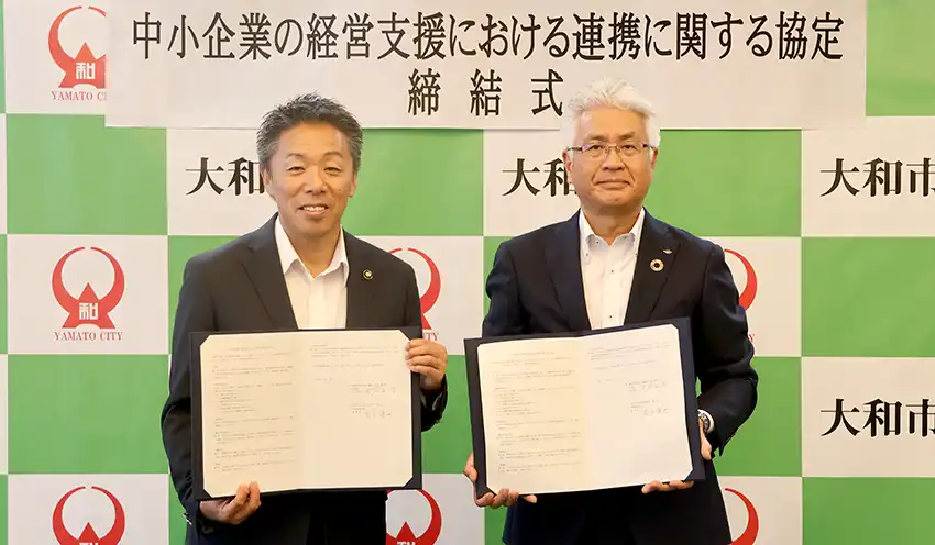 協定書を掲げる古谷田市長（左）と尾上理事長（8月22日、平塚信金提供）