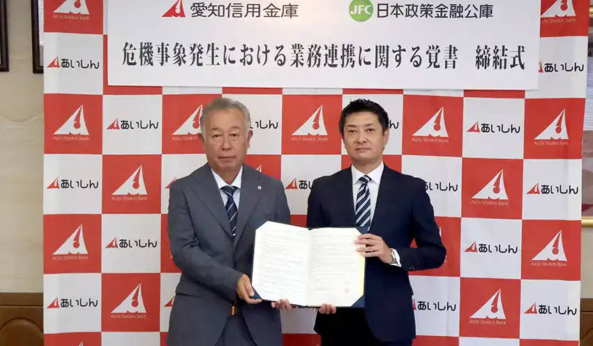 締結式に参加した(左から)本多理事長と横田支店長(8月28日、同信金本部)