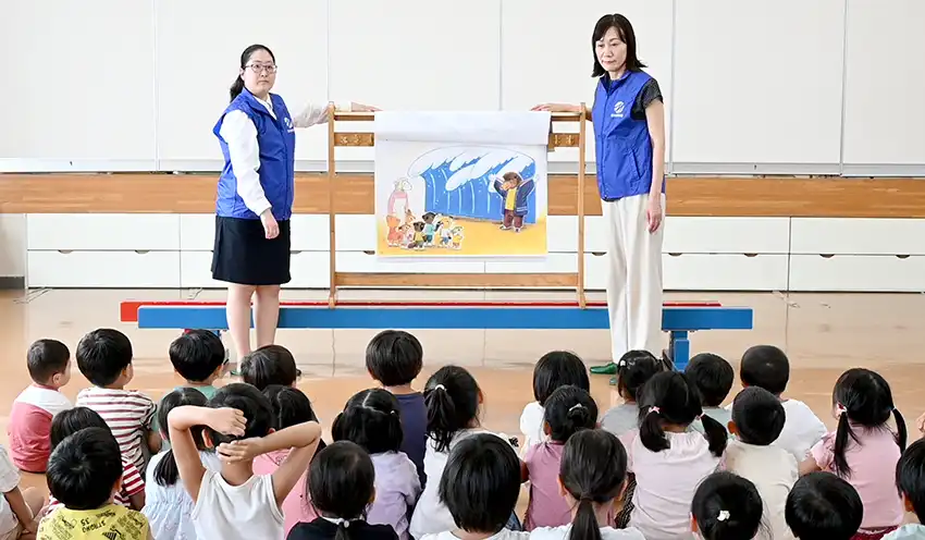 紙芝居で津波からの避難の重要性を教える職員（8月6日、そけい幼稚園）