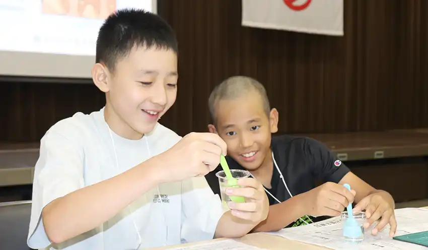 科学実験する小学生(8月7日、本部)