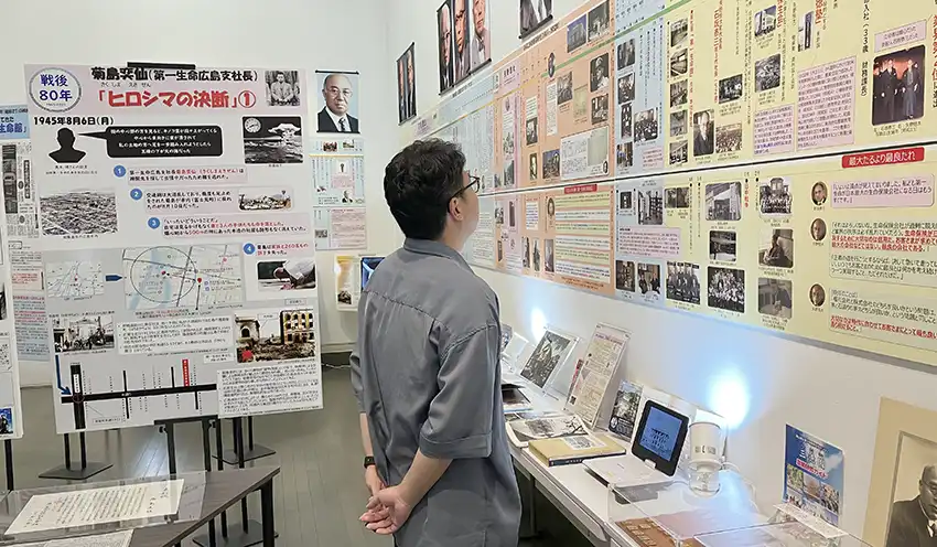 年表で改めて勤務先の歴史を感じる職員（8月15日、第一生命ギャラリー）