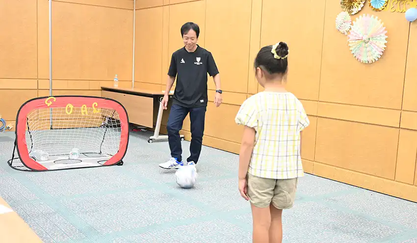 隅野社長は、「社員や家族など、皆が幸せに感じてもらえることが何よりも会社の経営にとって重要だ」と話した。 サッカーイベントでパスを出す隅野社長（8月18日、日比谷本社）
