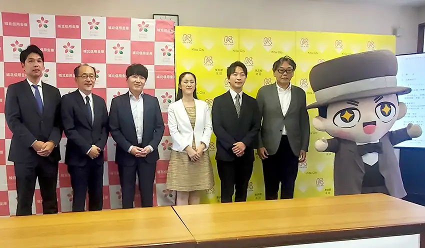 しぶさわくん(右)とともにセレモニーで記念撮影する関係者ら(8月26日、北区役所第一庁舎)
