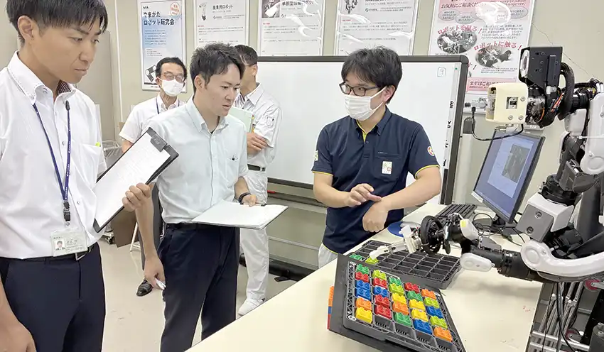 見学会にて工業技術センター職員から説明を受ける受講生（左、8月26日、山形県工業技術センター）
