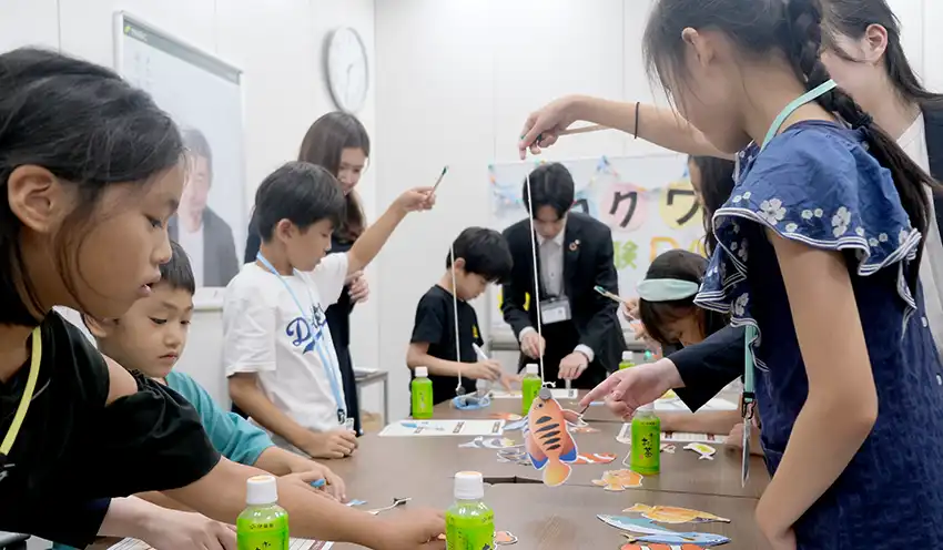 銘柄コードが記された魚の釣りを楽しむ子どもたち（8月8日、SMBC日興証券新宿支店）