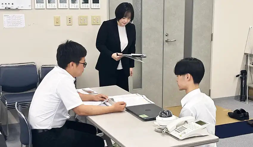 検定試験に向けてロープレ研修に取り組む東洋通信工業の社員と指導する大山氏（中央、東洋通信工業、CIS提供）