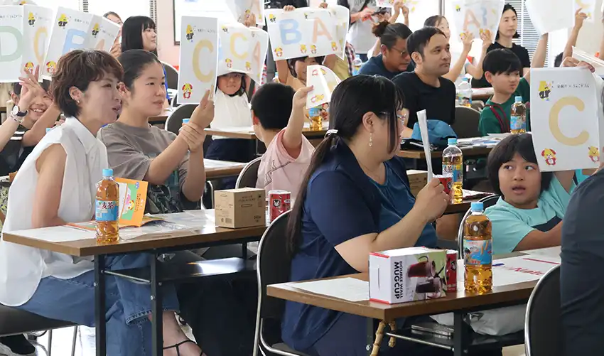 クイズに答える子どもと保護者（8月5日、熊本第一信金本店）