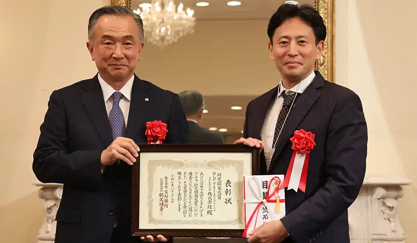 鶴久頭取（左）から赤畑代表取締役に表彰状と目録が手渡された（8月29日、ホテルマリターレ創世久留米）