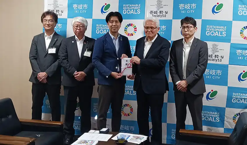 壱岐市の贈呈式では大久保運営委員(右から2人目)が篠原壱岐市磯焼け対策協議会会長(同3人目)に目録を贈呈した(8月4日、壱岐市役所、九州信漁連提供)