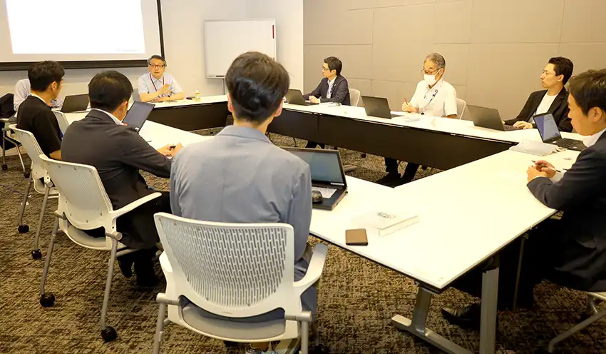 具体的な施策を話し合う大久保社長（左奥）と広島銀の本部行員ら（8月8日、ひろぎんホールディングス本社ビル）