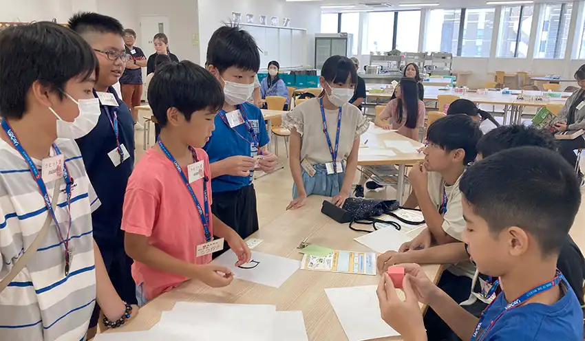 国に見立てたゲームで交渉する生徒ら（8月9日、琉球銀本店、琉球銀提供）