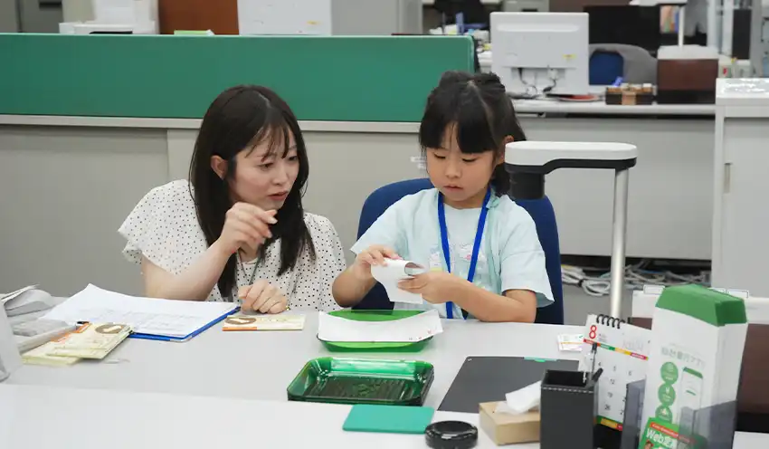 窓口業務を体験する行員の子供（8月7日、仙台銀本店）