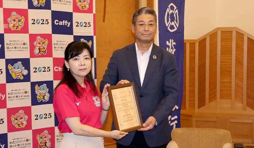 贈呈式で岸本副知事（左）と記念撮影に応じる山元常務執行役員（8月21日、滋賀県公館）