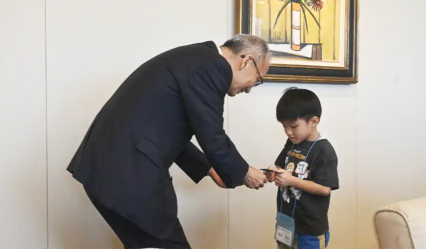高倉社長CEO（左）と名刺交換する参加者（8月6日）