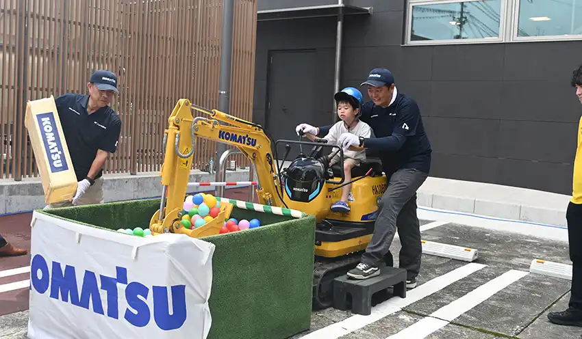 地元企業のブースで小型ショベルを体験する子供（8月2日、あぶくま信金本店）